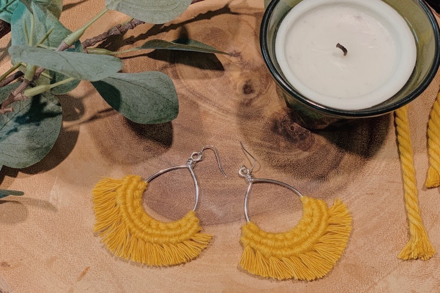 Pair of yellow handmade macrame earrings.