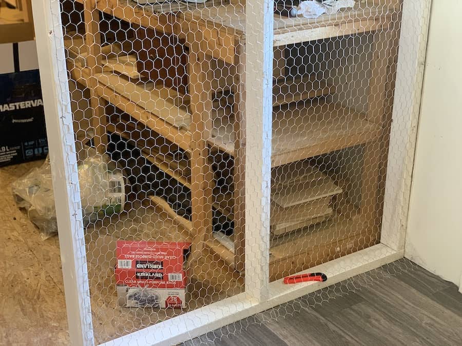 Chicken wire being installed to the inside frame of the chicken coop. 