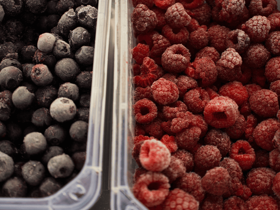 Frozen blueberries and raspberries in plastic containers.