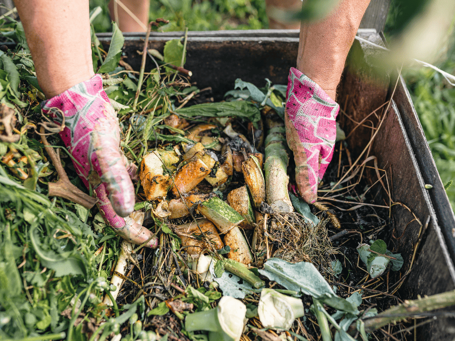 Zero waste kitchen, hands putting food scraps into a composter