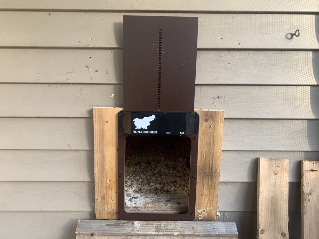 Our brown Run-Chicken automatic door opened while attached to the chicken coop.